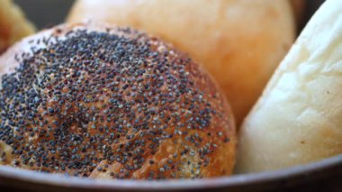 Çeşit çeşit ekmek ruloları bir kasede dinleniyor, altın kabuklar ve dokular sergileniyor..