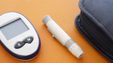 Kan şekeri seviyelerini kontrol etmek için glikoz ölçer ve mızraklama aygıtı görüntülendi.