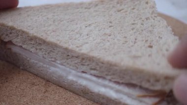 Tam tahıllı ekmek ve hindi dilimleri kullanarak hindili sandviç hazırlamak..