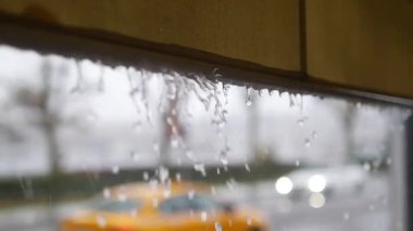 Şehir merkezindeki çatıdan çağlayan yağmur suyu,