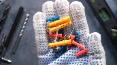 DIY görevleri için eldivenli elle tutulan çeşitli bağlayıcıların yakın plan görüntüleri.