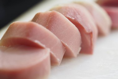 Taze ton balığının parlak renkli dilimleri kesme tahtasının üzerinde düzgünce duruyordu..