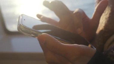 Teknede akıllı telefon kullanan biri..