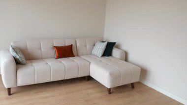 Modern bir kanepesi ve renkli yastıkları olan rahat bir oturma odası..