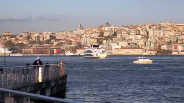 İstanbul şehri gün batımında ışıldarken, tekneler denizde yüzüyor.