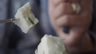 Kalabalık bir pazarda yerel otlarla hazırlanmış taze peynirin tadını çıkarıyorum..