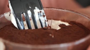 Çatal, kremalı, çikolatalı, zengin bir tatlıyı kazıyor..