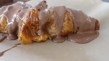 Taze pişmiş kruvasan, üstüne çikolata sosu, tadını çıkarmaya hazır..