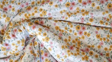 Çiçek desenli yumuşak bir yatak, odaya sıcaklık ve konfor getirir..