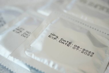 Önemli tarihleri gösteren paketlenmiş prezervatiflerin yakın görüntüsü.
