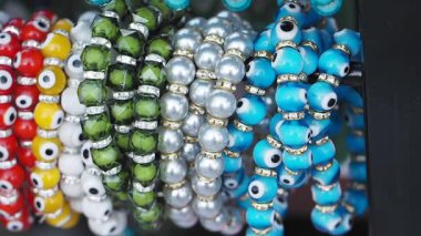 Hareketli bir pazarda sergilenen canlı boncuklu bilezikleri keşfedin..