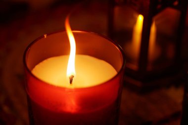 Sıcak bir mum ışığı nazikçe yanıp sönüyor ve içeride sakin bir atmosfer yaratıyor..