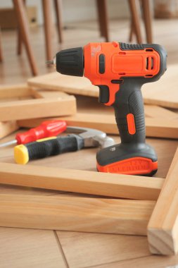 Bir matkap ve el aletleri kapalı alanda ahşap çerçeveler üzerinde düzenlenir..