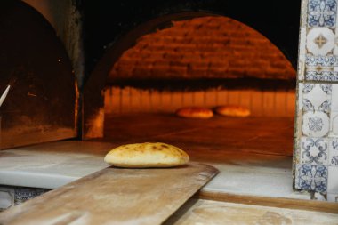 Ekmek, sıcak fırının yanındaki tahta kürekte duruyor..