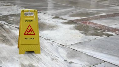 Uyarı işareti, yoğun bir yerde ıslak bir kat olduğunu gösteriyor..