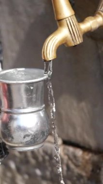 Pirinçten akan su, doğal bir yerde gümüş bir kaba akıyor..