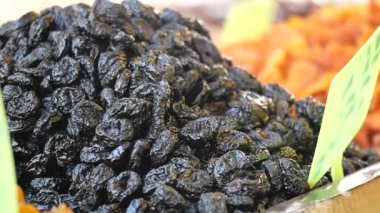 Hareketli bir pazarda kurumuş kara meyvelerin yakın çekimi.