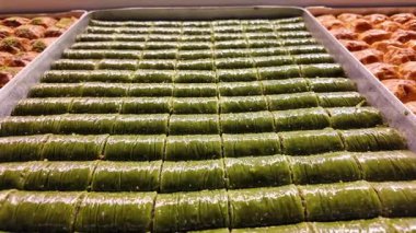 Yetenekli fırıncıların hareketli bir tatlı dükkanında taze baklava yapmalarını izle..