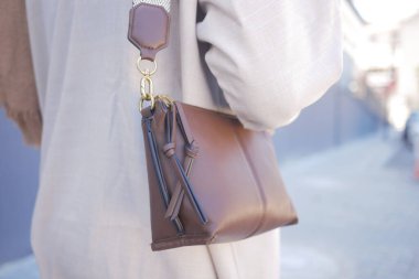 Şehrin arka planında sergilenen şık kahverengi bir deri çanta..