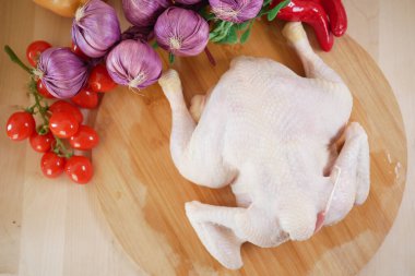 Taze tavuk canlı sebzelerle çevrili, pişirmeye hazır..