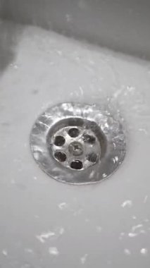 Etrafında kabarcıklar oluşurken, su paslanmaz çelik bir drenaja dönüşür..