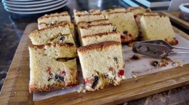 Renkli pasta dilimleri bir kafede ahşap bir tahtada düzgünce düzenlenir..