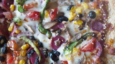 Canlı, taze sebzeli ve erimiş peynirli ev yapımı pizzanın tadını çıkar..