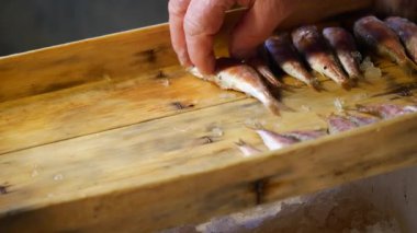 Taze balık bakılıyor ve marketteki ahşap tepside düzenleniyor..