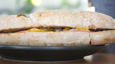 Köy tabaklarında taze malzemelerle dolu lezzetli bir sandviç servis edilir..