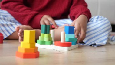 Çocuk renkli tahta bloklarla oynar, onları dizer ve dizer..