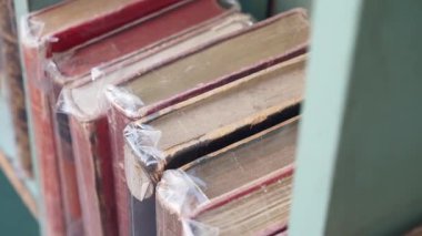 Bir markette muhafaza etmek için sarılmış eski kitap koleksiyonunu inceleyin..