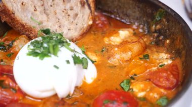 Lezzetli kahvaltıda haşlanmış yumurta, domates ve kabuklu ekmek var..