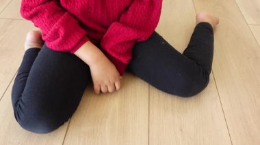 Serebral felçli çocuk ahşap zeminde oturuyor. .