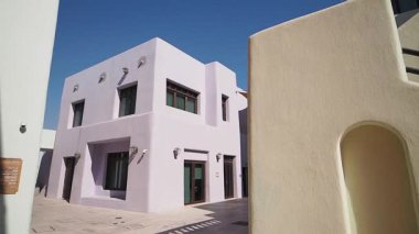 Tuhaf yapı, açık mavi gökyüzü altında benzersiz tasarım özellikleri sergiler.