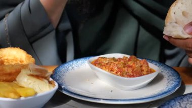 Ekmek ve yanlarla servis edilen lezzetli yerel yemeğin tadını çıkaran eller..