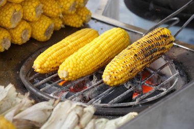 Mısır koçanları bir sokak pazarında kızgın kömürlerin üzerinde kızartılıyor..