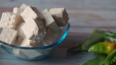 Taze tofu küpleri canlı biberlerin yanında oturur ve yerel pazar sunumlarını sergiler..