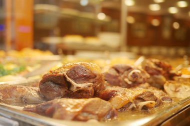 Dolgun bir restoran büfesinde leziz et seçenekleri sunuluyor..