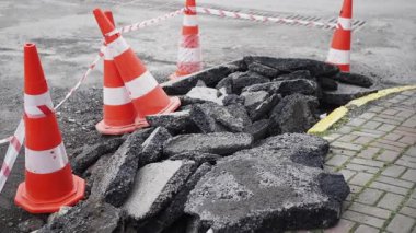 Yol çalışmaları, kamu güvenliği için güvenlik konileri tarafından engellenmiş beton enkazı gösteriyor..