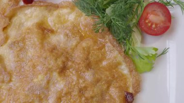 Taze yeşillikler ve vişneli domateslerle birlikte lezzetli bir omlet tabağı..