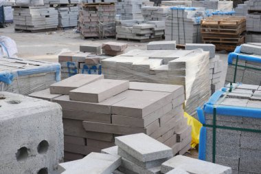 İşçiler yoğun bir inşaat alanında beton bloklar düzenliyorlar.
