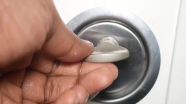 Bir el, evdeki ya da ofisteki kapıyı açmak için kapı kolunu çevirir..