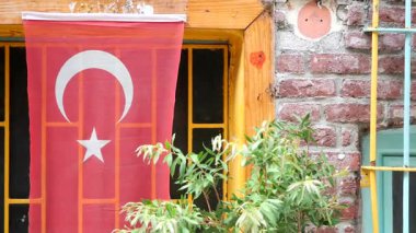 Geleneksel Türk bayrağı yakındaki yemyeşil binaları süslüyor.