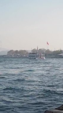 Rüzgarda dalgalanan bayraklar gibi sakin sularda hareket eden sakin bir tekne..