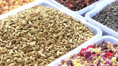 Renkli tepsilerde sergilenen çeşitli baharat ve bitkiler keşfedin..