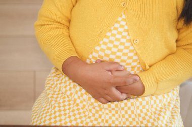 Koltukta oturan çocuk karın ağrısı çekiyor. .