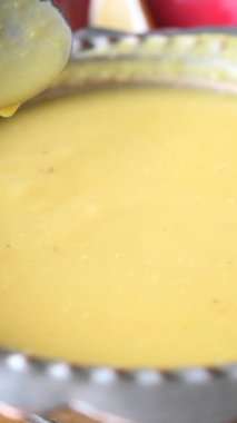 Bir şef taze malzemelerle bir tencere kremalı çorba karıştırır..