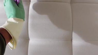 Bir insan, lekeleri ve kiri temizlemek için nazikçe kumaş yüzeyi ovalıyor..