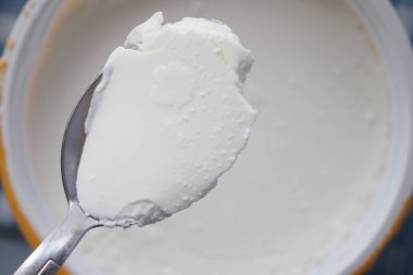 Bir kaşık yumuşak ve kremalı yoğurdu tadını çıkarmaya hazır tutar..