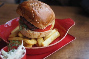 Ağız sulandıran hamburgerin üstüne sebze ve patates kızartması..